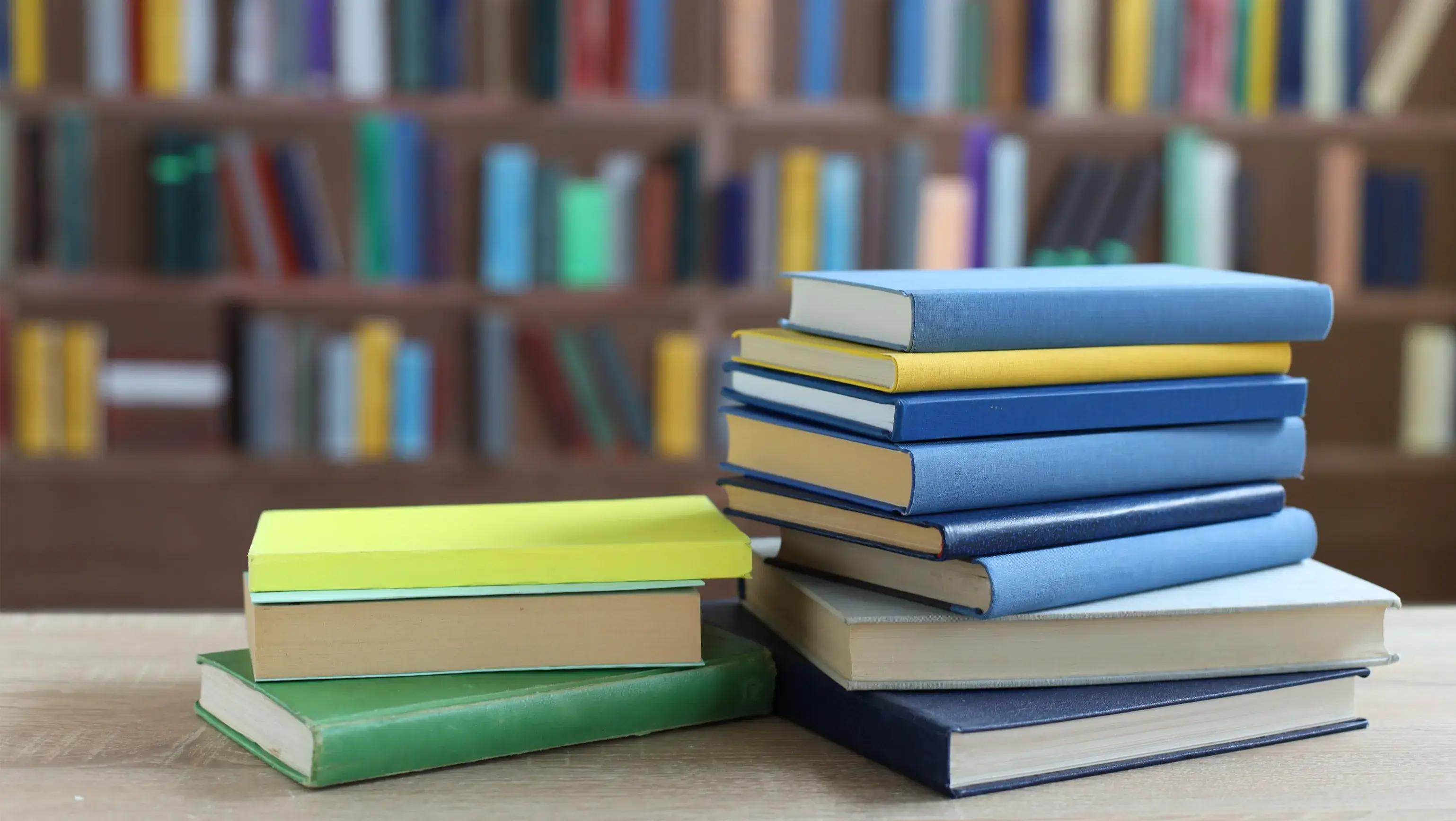 Stack of books on a desk inside of a library